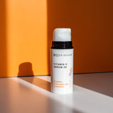 Vitamin C Serum 25 bottle in the shadows against orange background